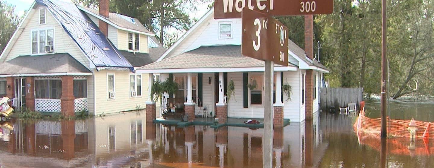 flooded water street in wooded neighborhood