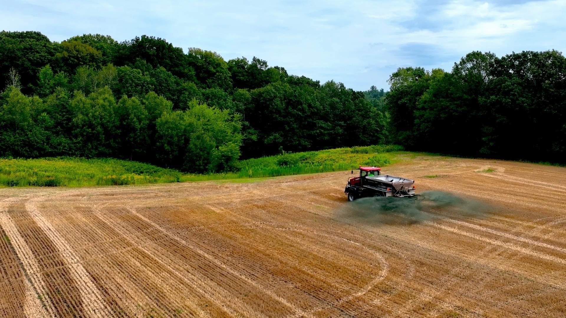 A truck spreading rock dust on a crop field. Photo courtesy of Sunrock Industries.