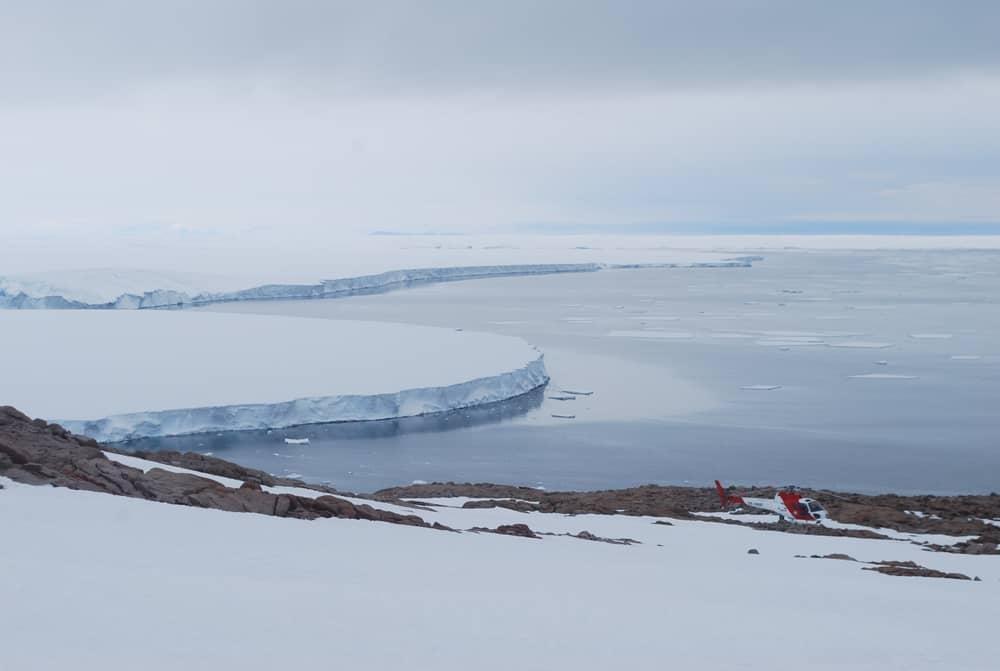 cape irizar in antarctica with helicopter sitting on ground in distance