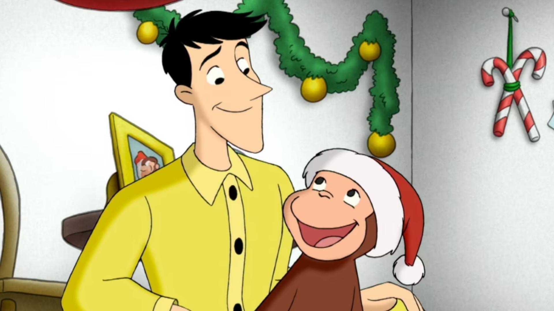 The Man with the yellow hat holding Curious George wearing a Santa hat.