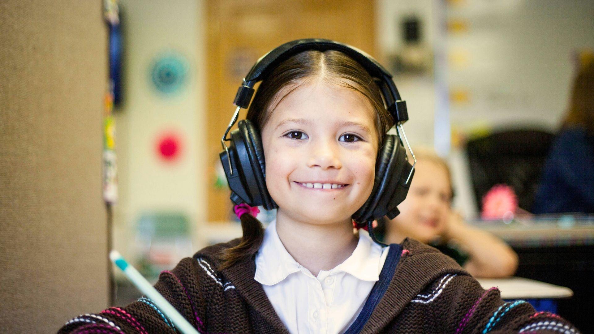 A child smiles with headphones on.