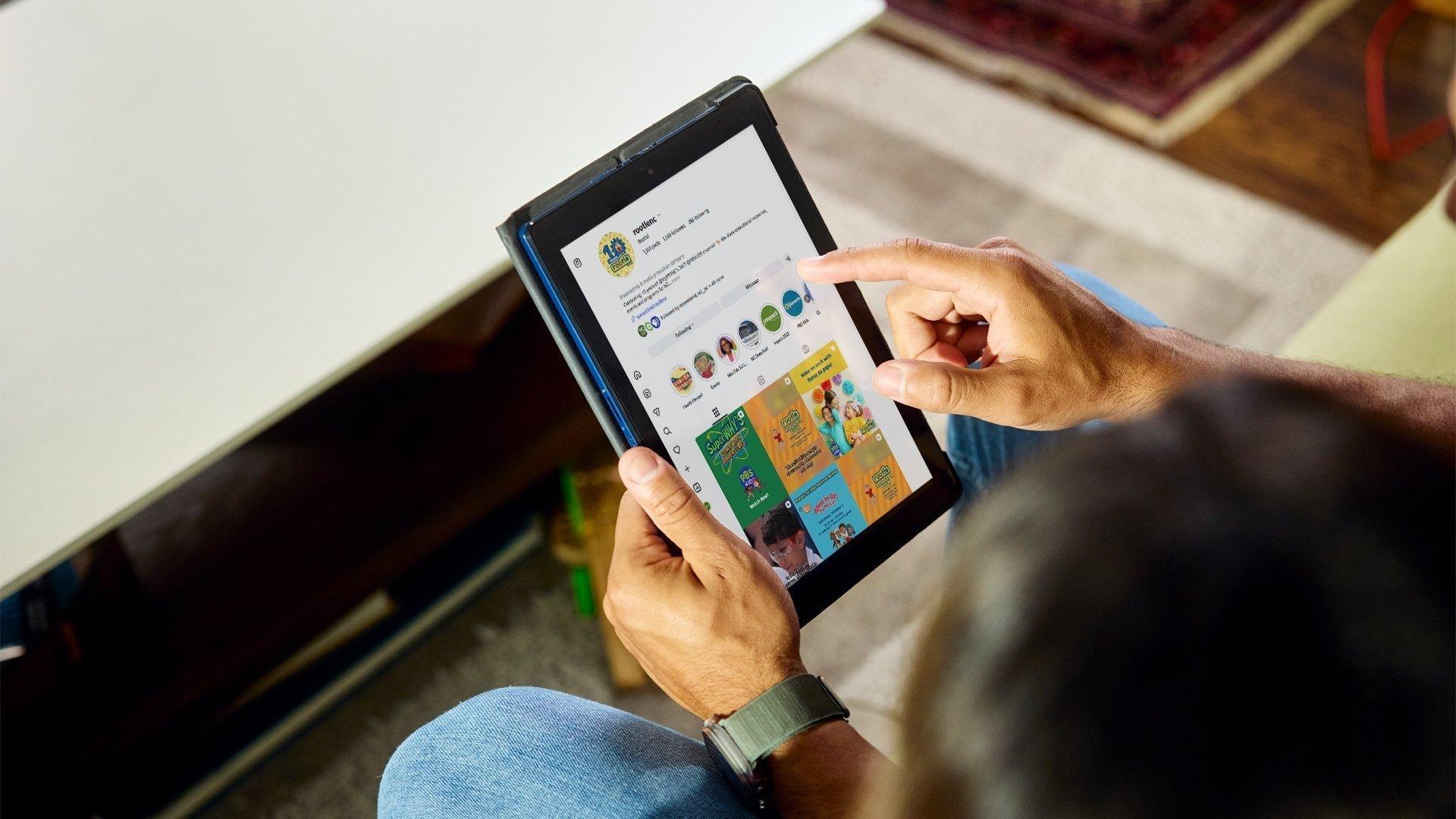 A person holding a tablet with the Rootle Instagram account page pulled up.