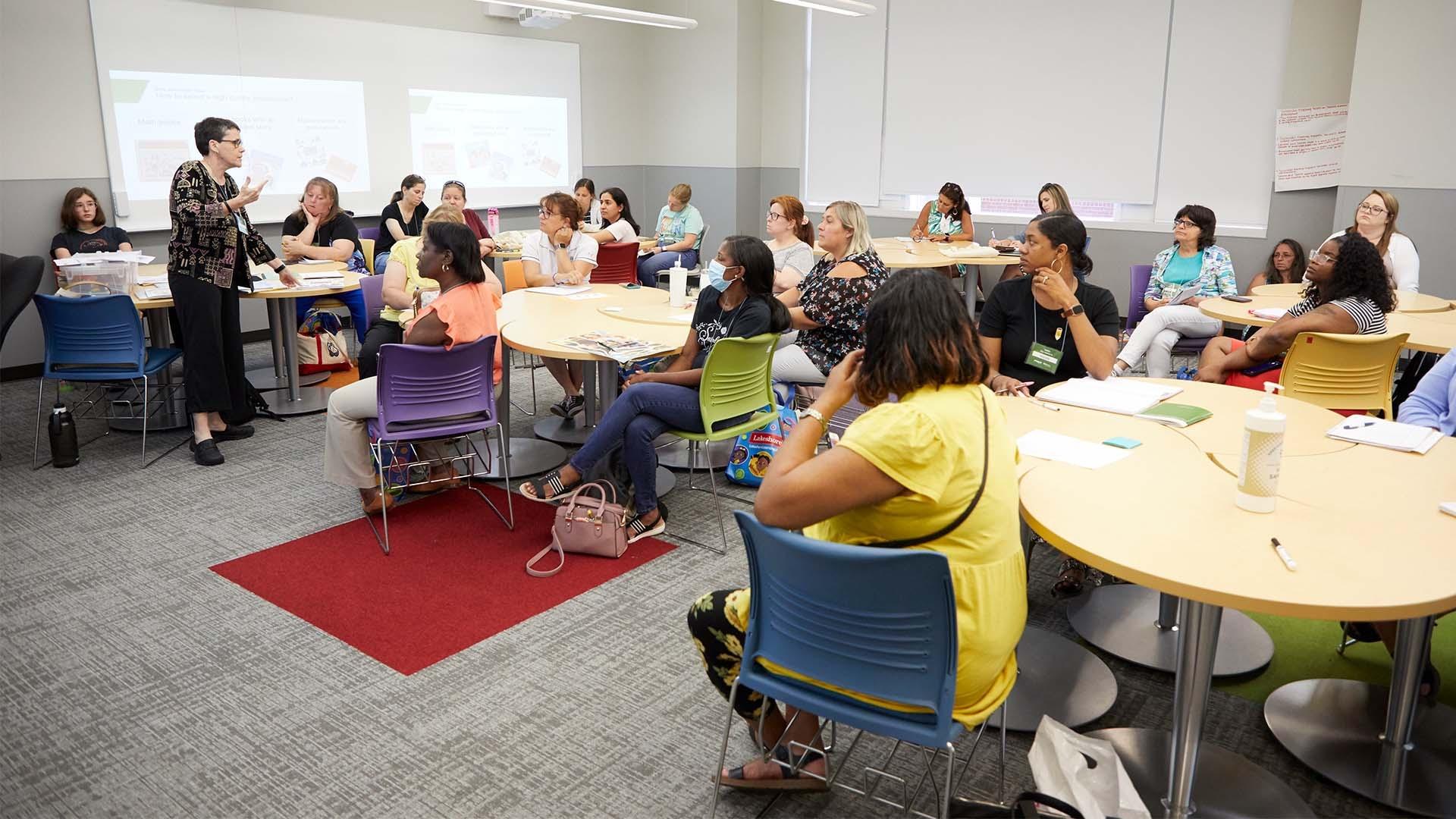 Instructor with audience at the Impact Summit