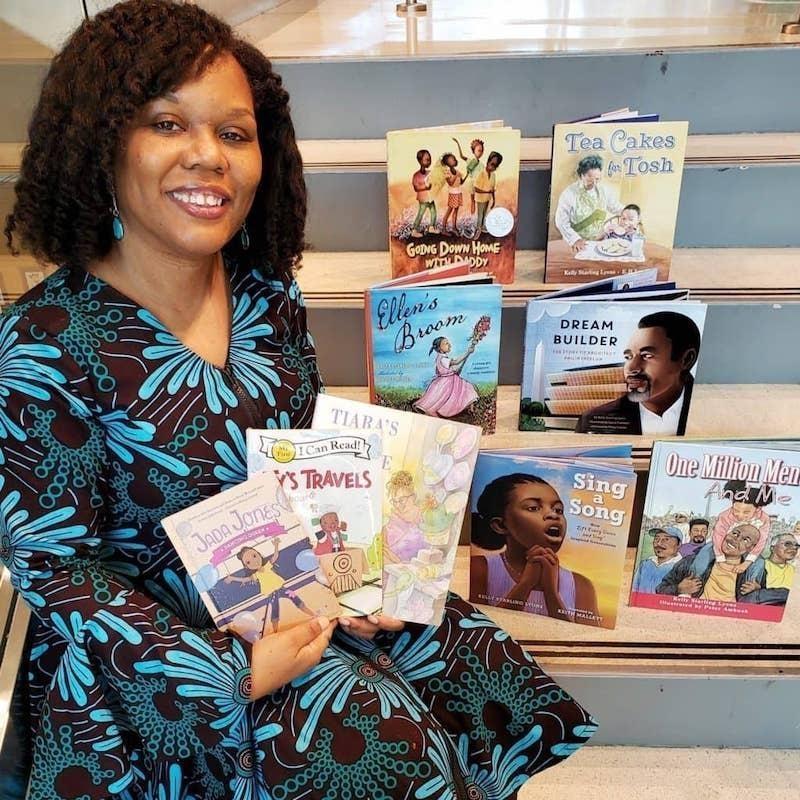 Kelly Starling Lyons holding books with strong black characters 