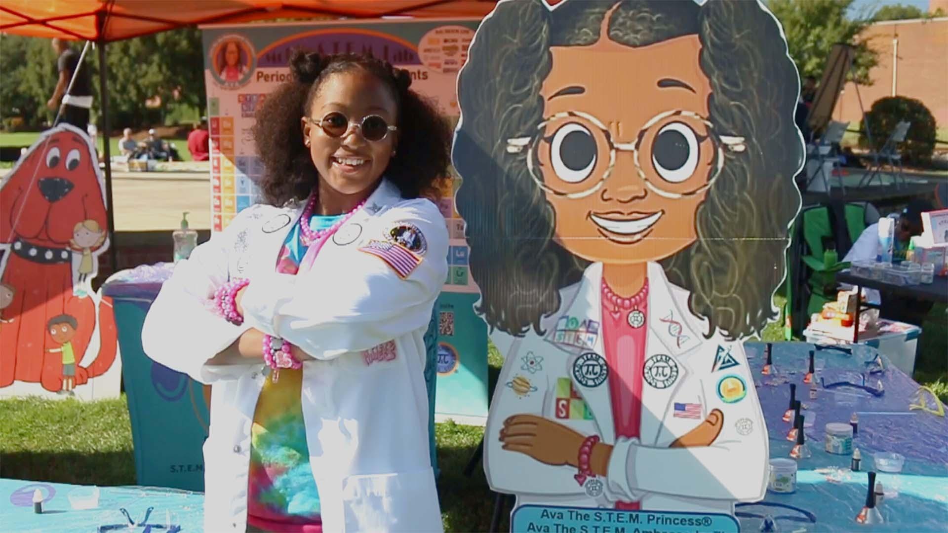 Ava the STEM Princess poses with a cardboard cutout of herself at a Rootle Roadster Tour stop.