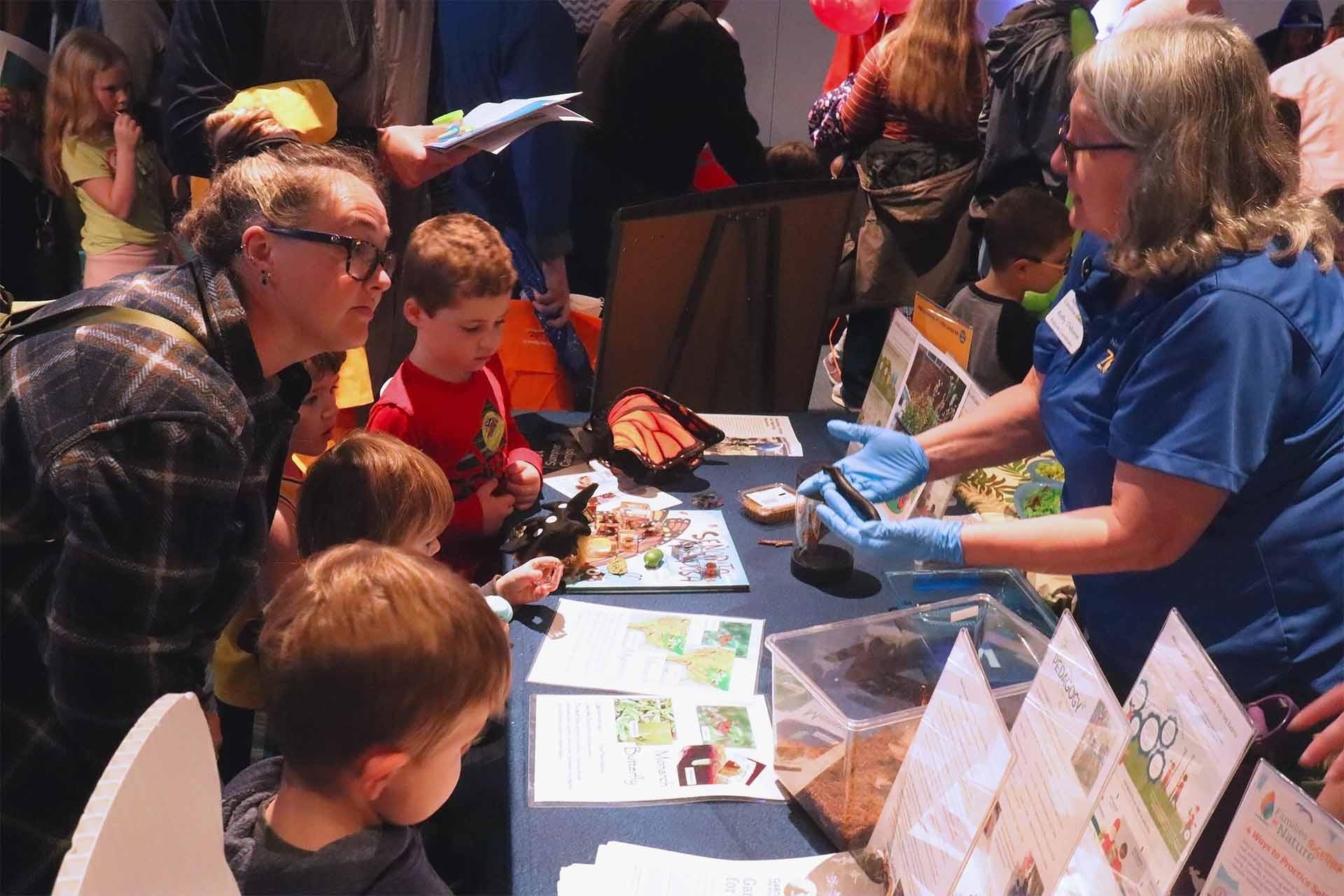 Children and caregivers around a demonstration table.