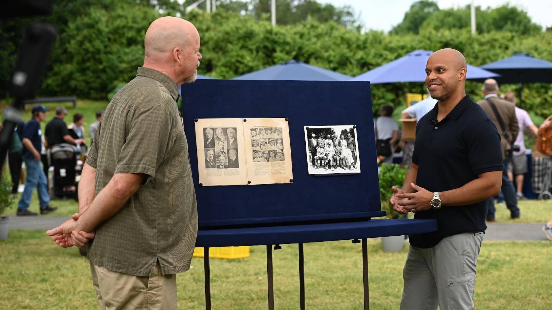 Jasmani Francis (right) appraises a 1939 autographed Baseball Hall of Fame program, in Raleigh, NC. ​​ANTIQUES ROADSHOW “North Carolina Museum of Art, Hour 1” airs Monday, April 1 at 8/7C PM on PBS. Photo by Meredith Nierman for GBH, © 2024 WGBH Educational Foundation.