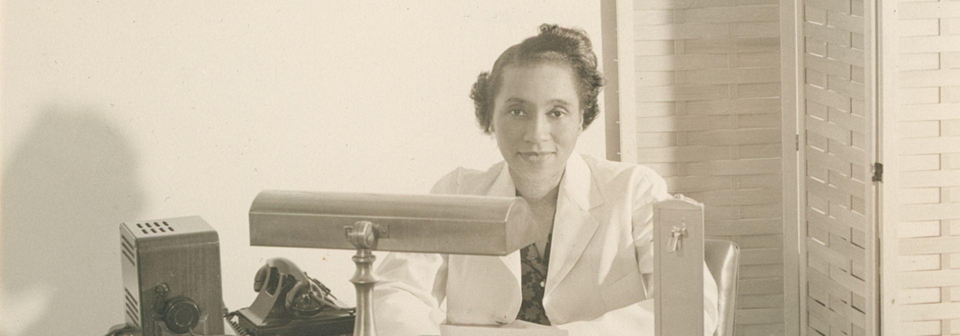 Dr. Helen Dickens at a desk.