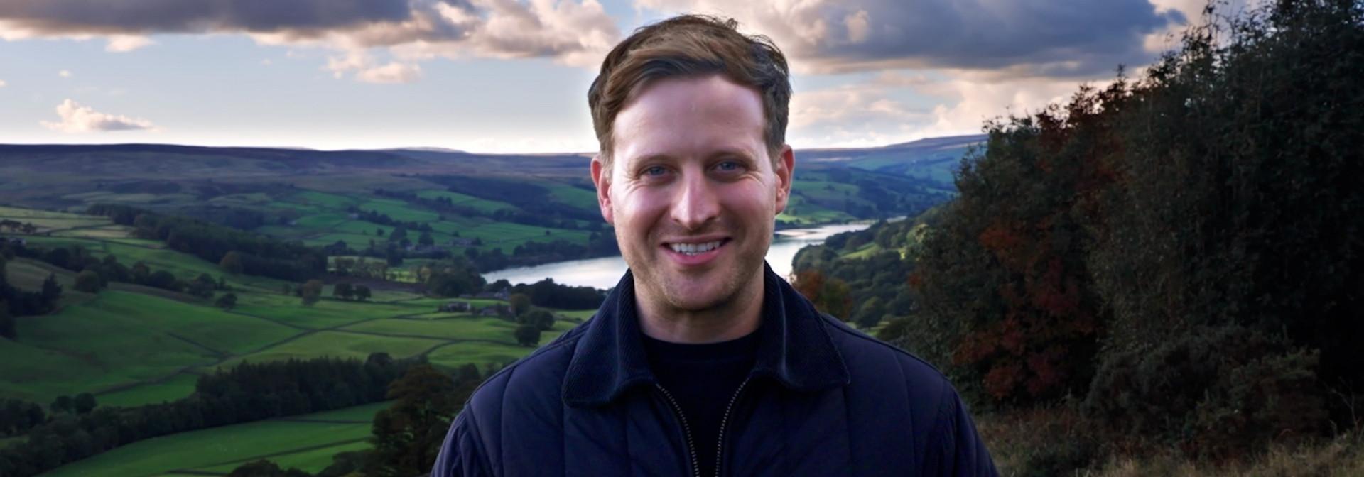 Nicholas Ralph with the Yorkshire Dales behind him.