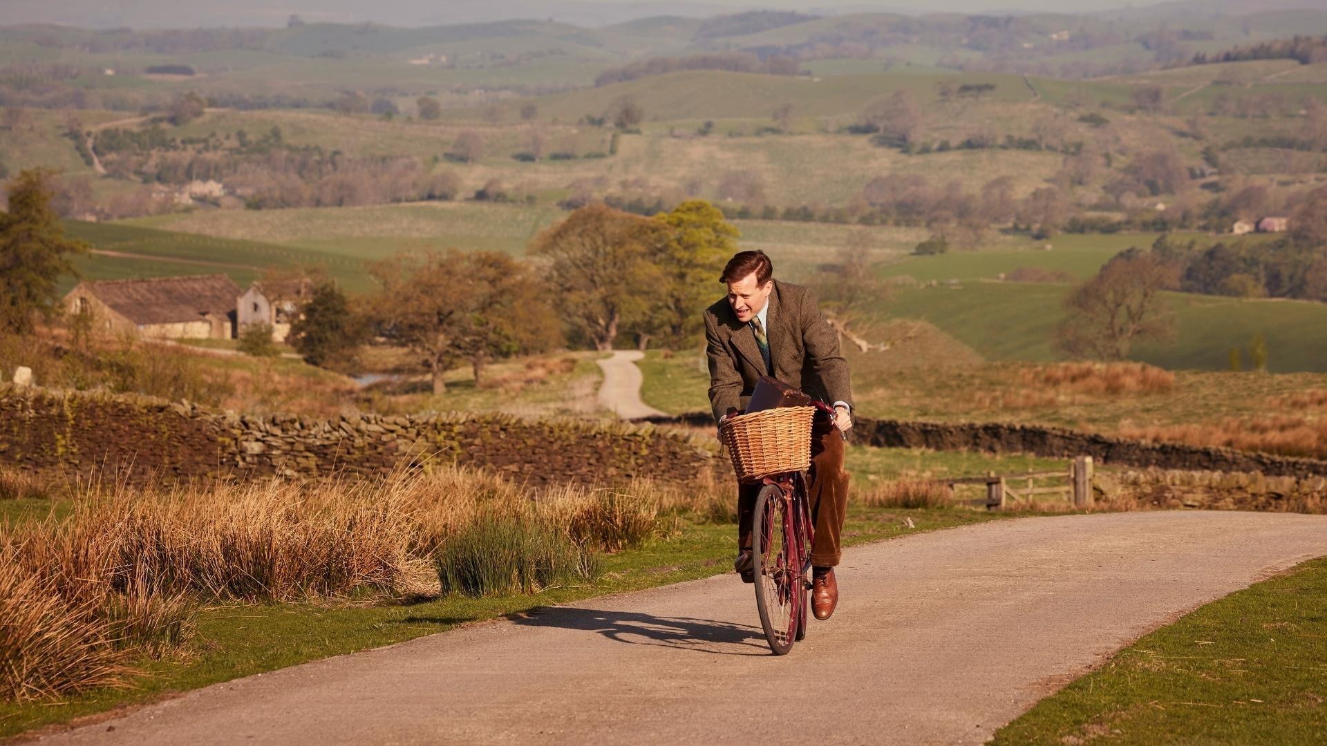 All Creatures Great & Small actor Nicholas Ralph riding a bicycle.