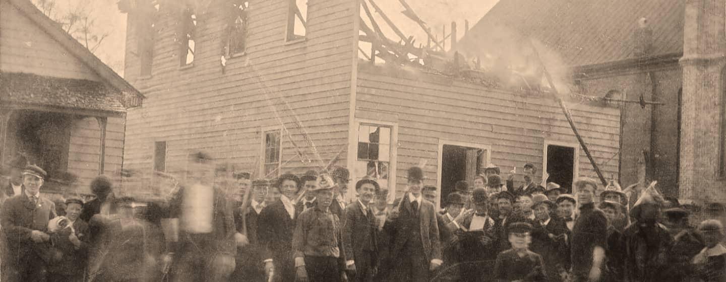 Men standing outside the Daily Register after it was burned during the Wilmington Insurrection of 1898