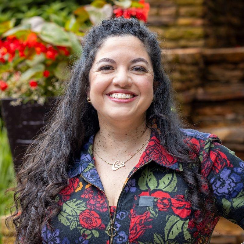 Von Diaz smiling in front of a garden.