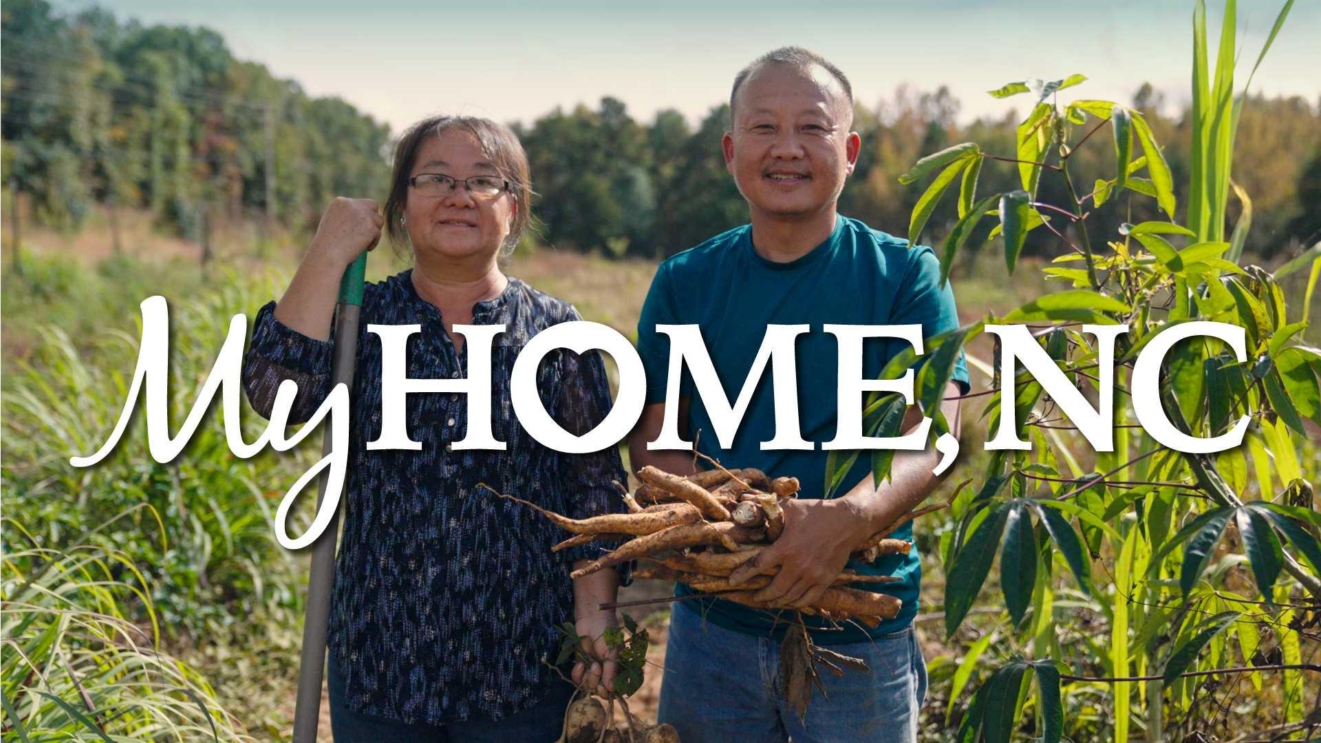 Two farmers stand side by side in a rice field with the "My Home NC" logo over the image