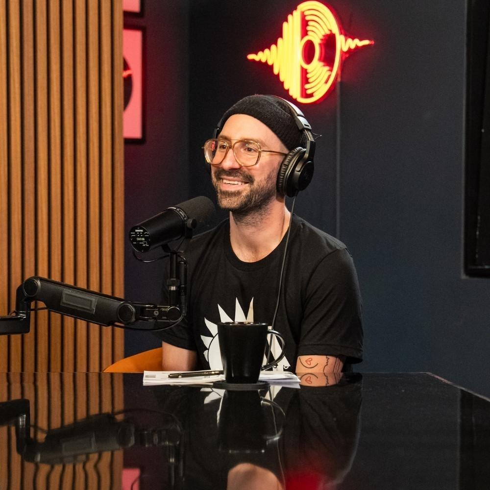 Host of Shaped by Sound, James Mieczkowski, in the podcast studio with headphones on and a mic in front of him.