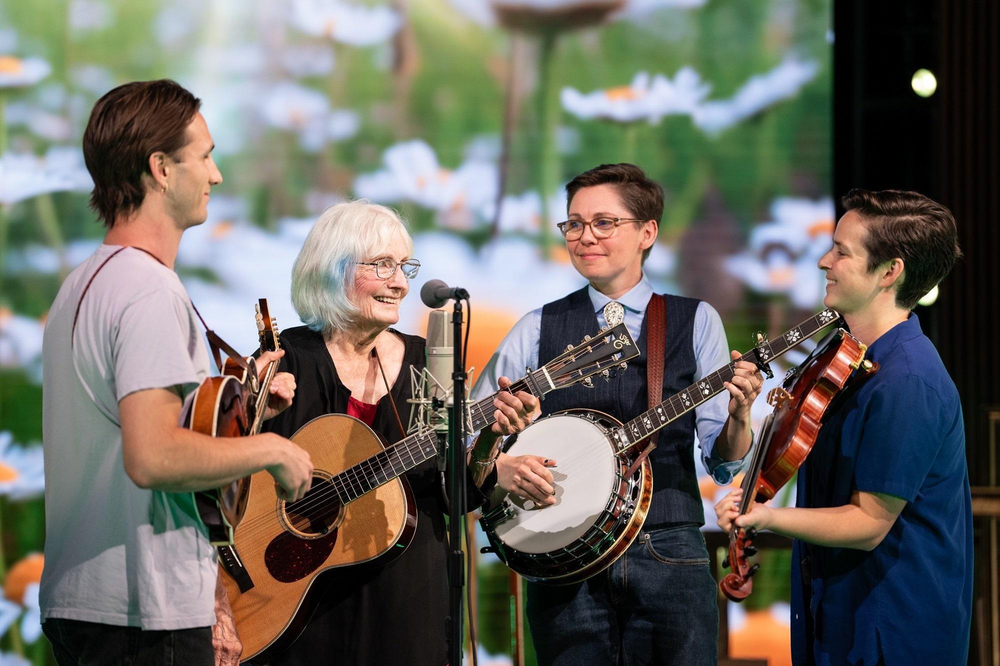 Alice Gerrard and her bandmates playing quartet style into a single microphone.