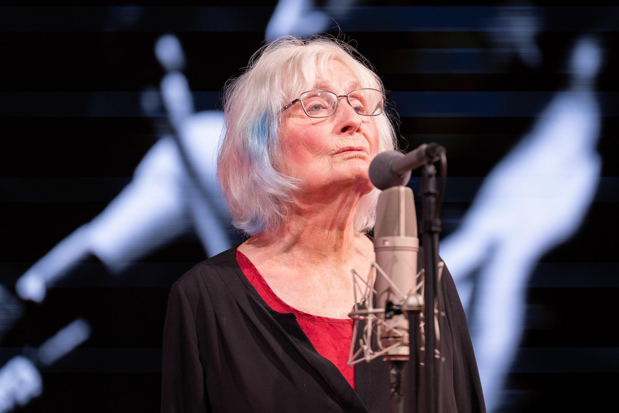 Alice Gerrard singing into a microphone.