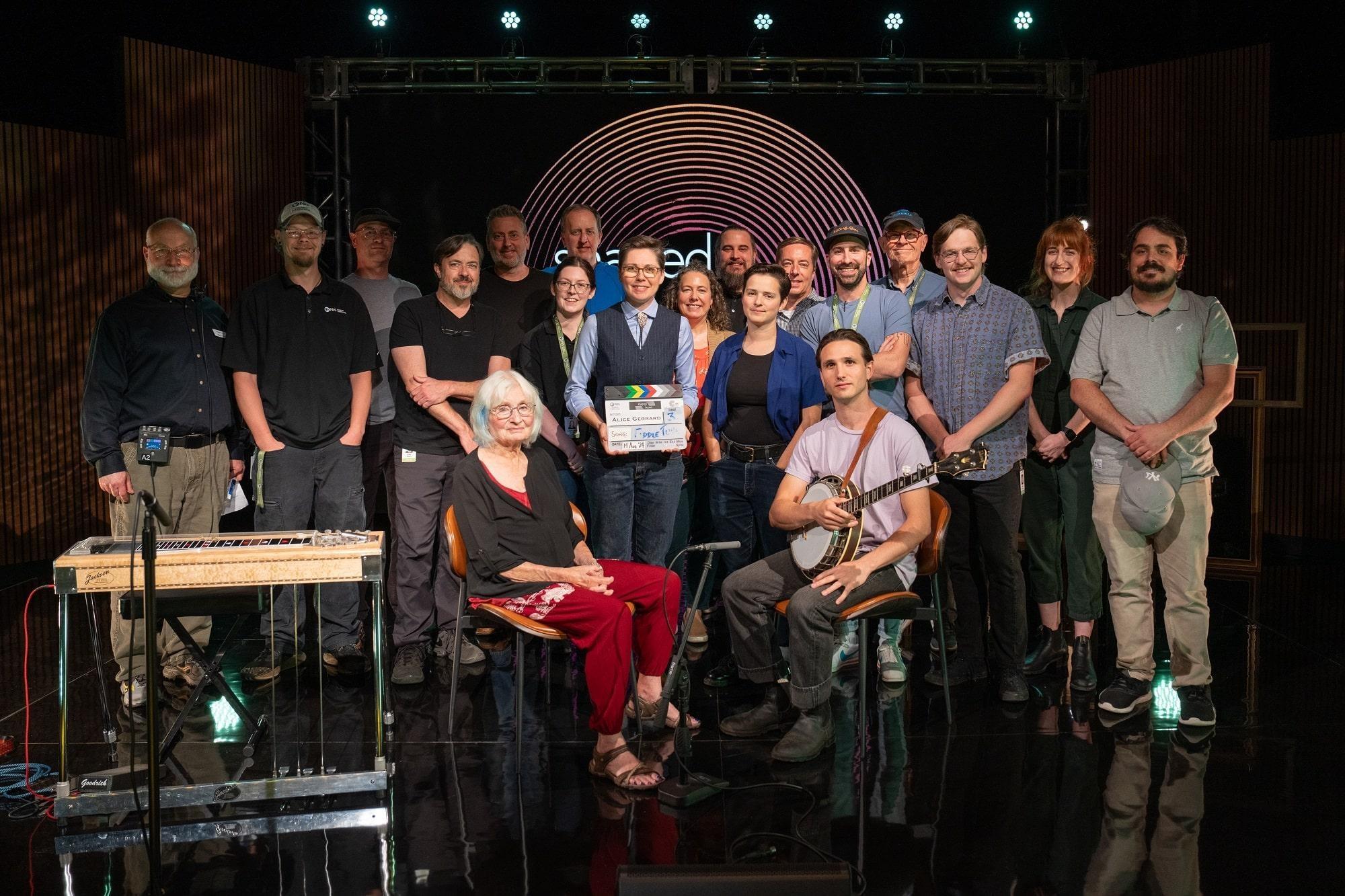 Alice Gerrard, her band and the Shaped by Sound production team posing as a group on set.