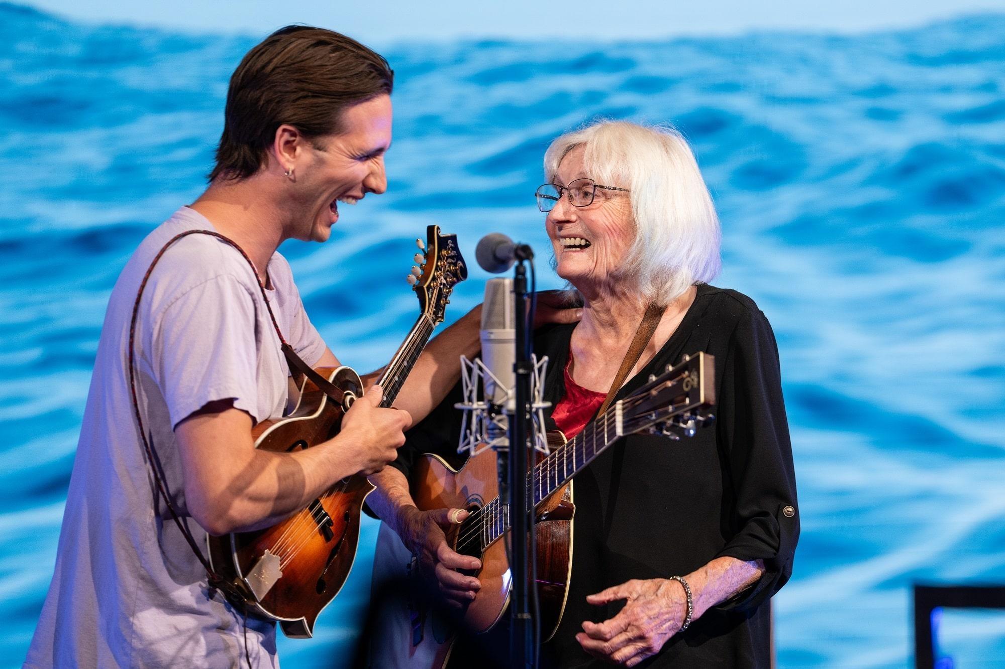 Alice Gerrard is joined by a bandmate, singing into the microphone.