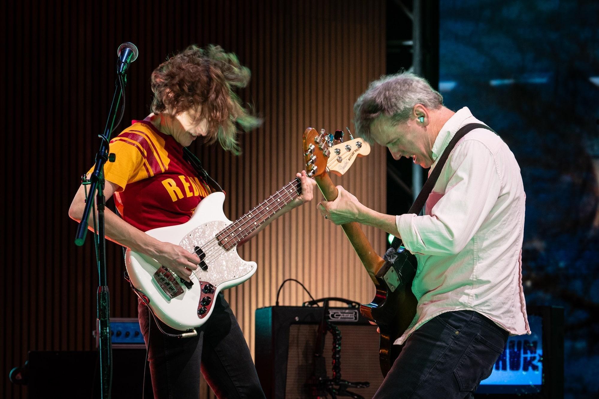 Laura Balance and Mac McCaughan of Superchunk playing guitar together on set.