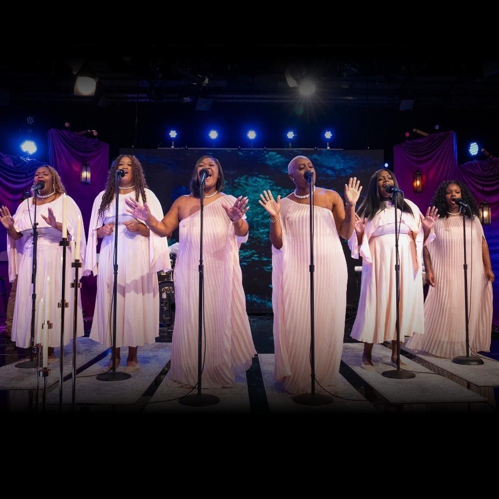 Singers in Faith and Harmony singing into microphones on the set of Shaped by Sound.