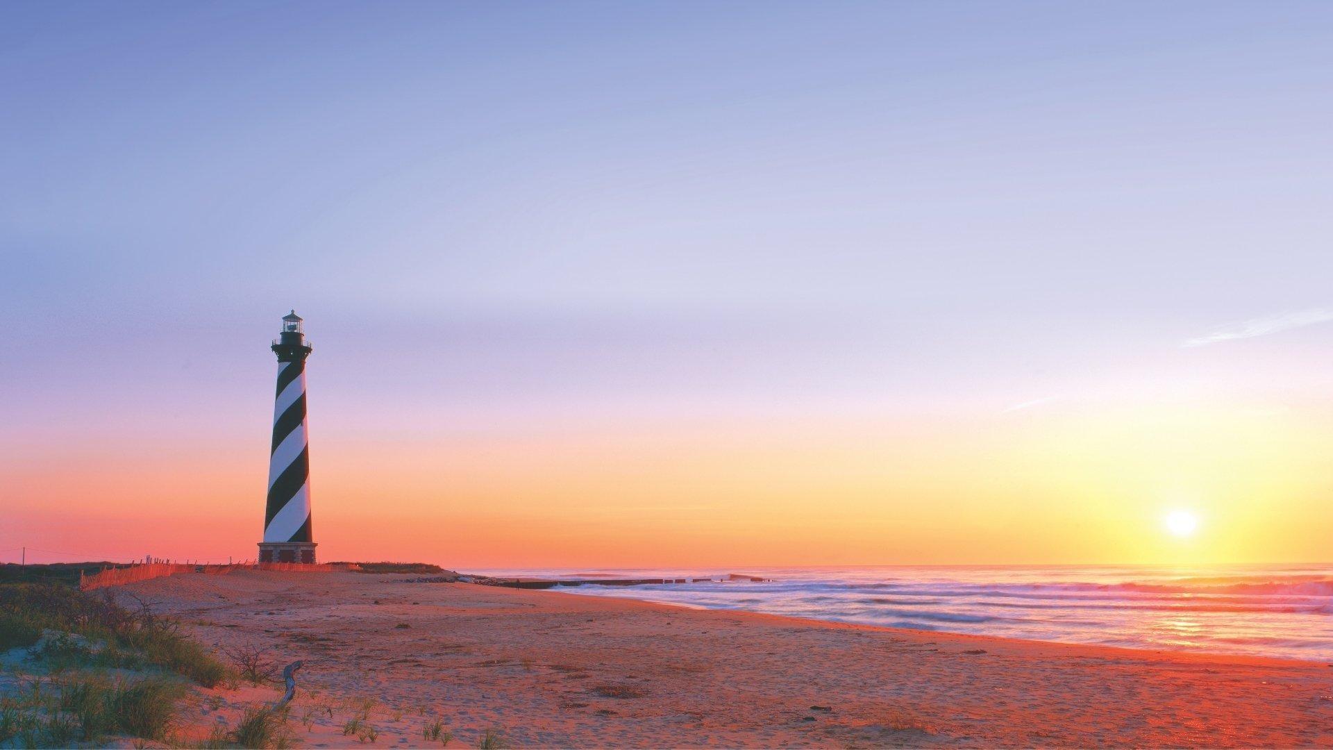 A sunrise on Cape Hatteras, behind the black and white lighthouse.