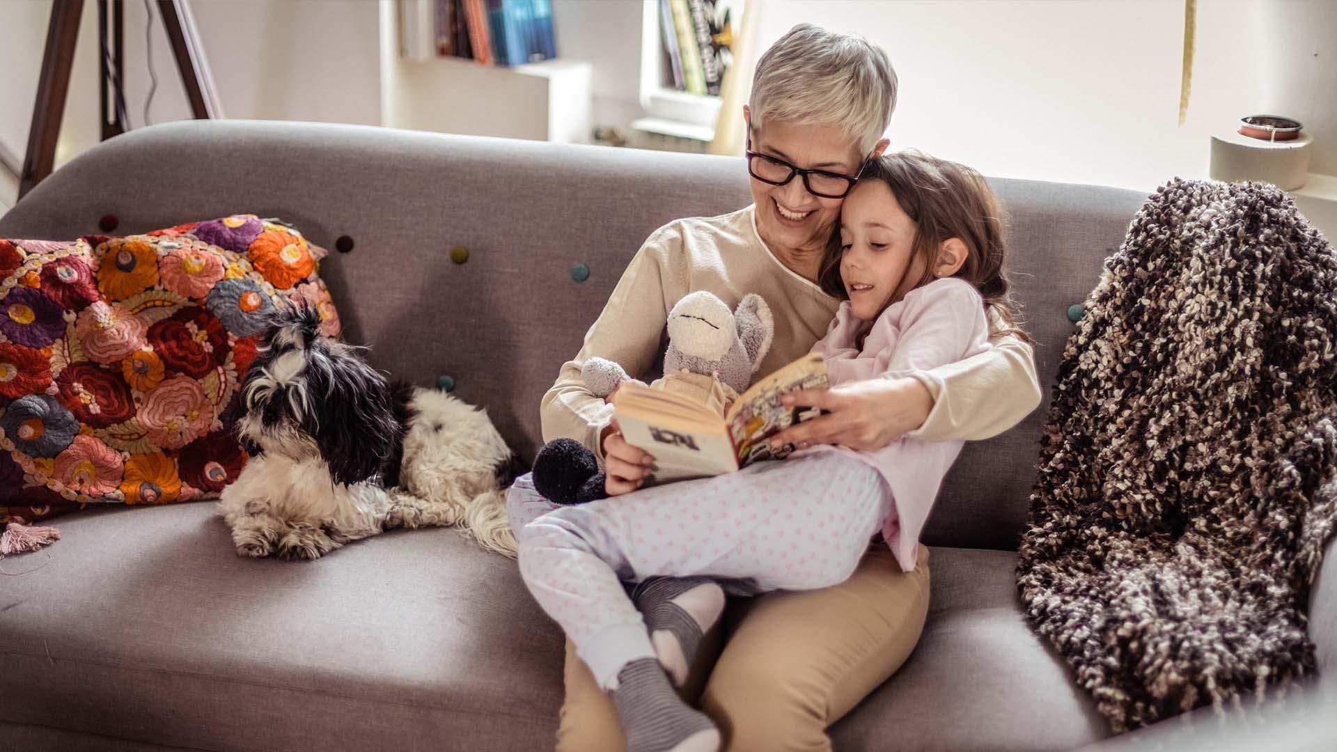 Grandmother and child reading books on the couch