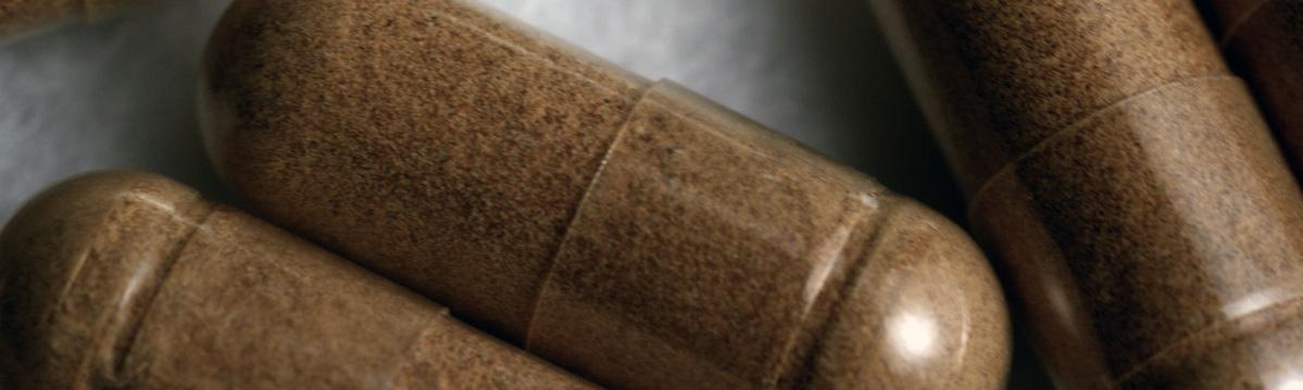 Photo of 3 kratom capsules on a table