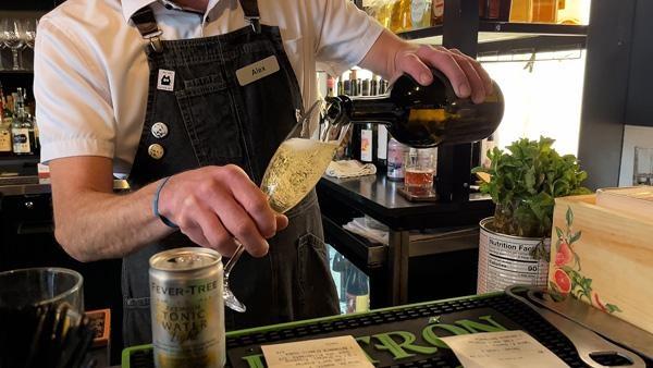 Restaraunt worker pouring a cold glass of alcohol.