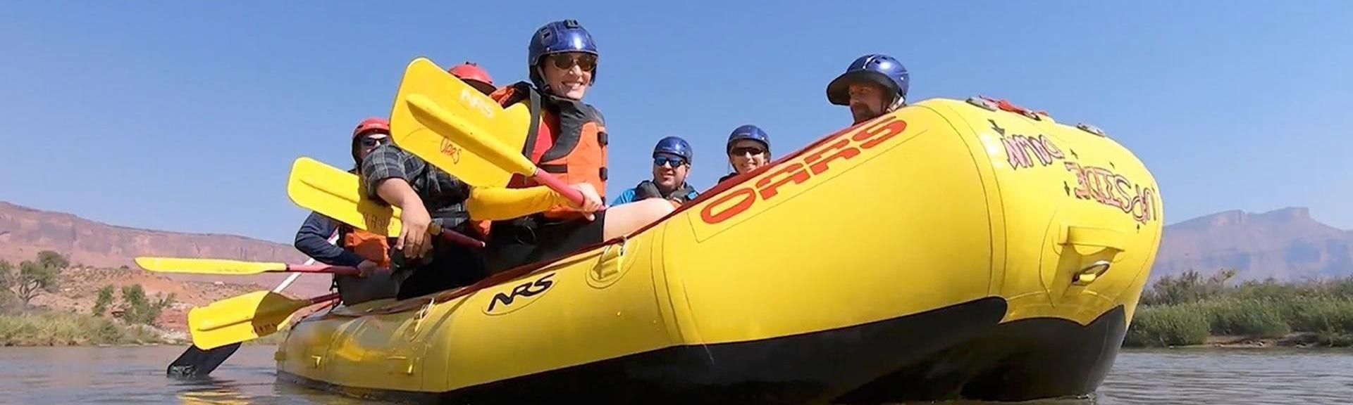 Happy people on yellow raft in a big river