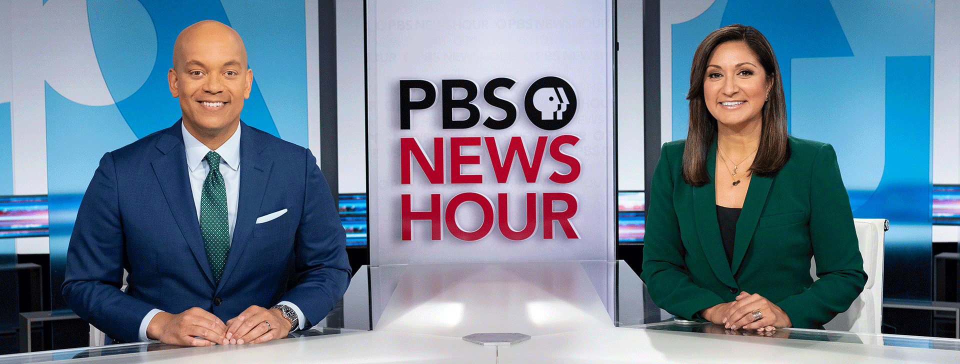 PBS News Hour Hosts sitting at desk