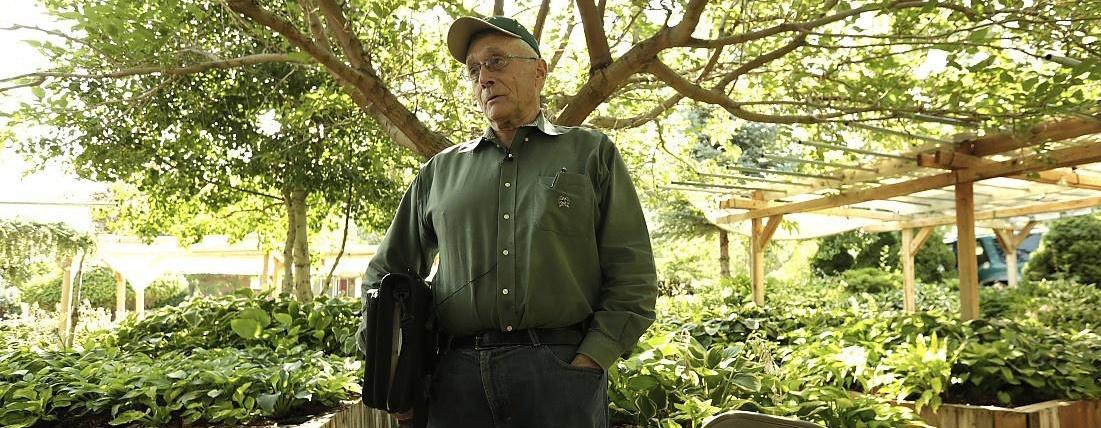 Burton Johnson standing in a Hosta garden