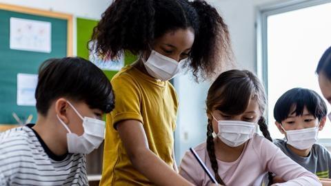 Kids with masks on their faces in a classroom