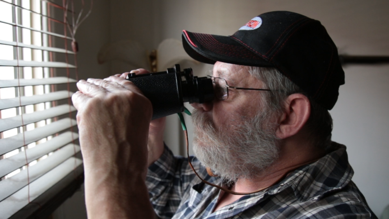 photo of an older man looking through binoculars