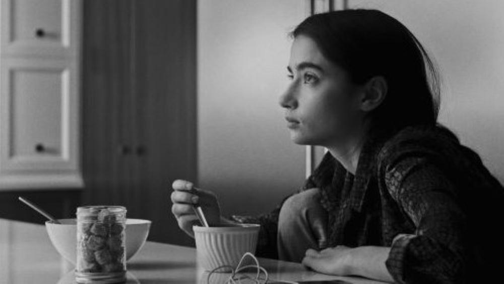 black and white photo of a woman at table with bowls