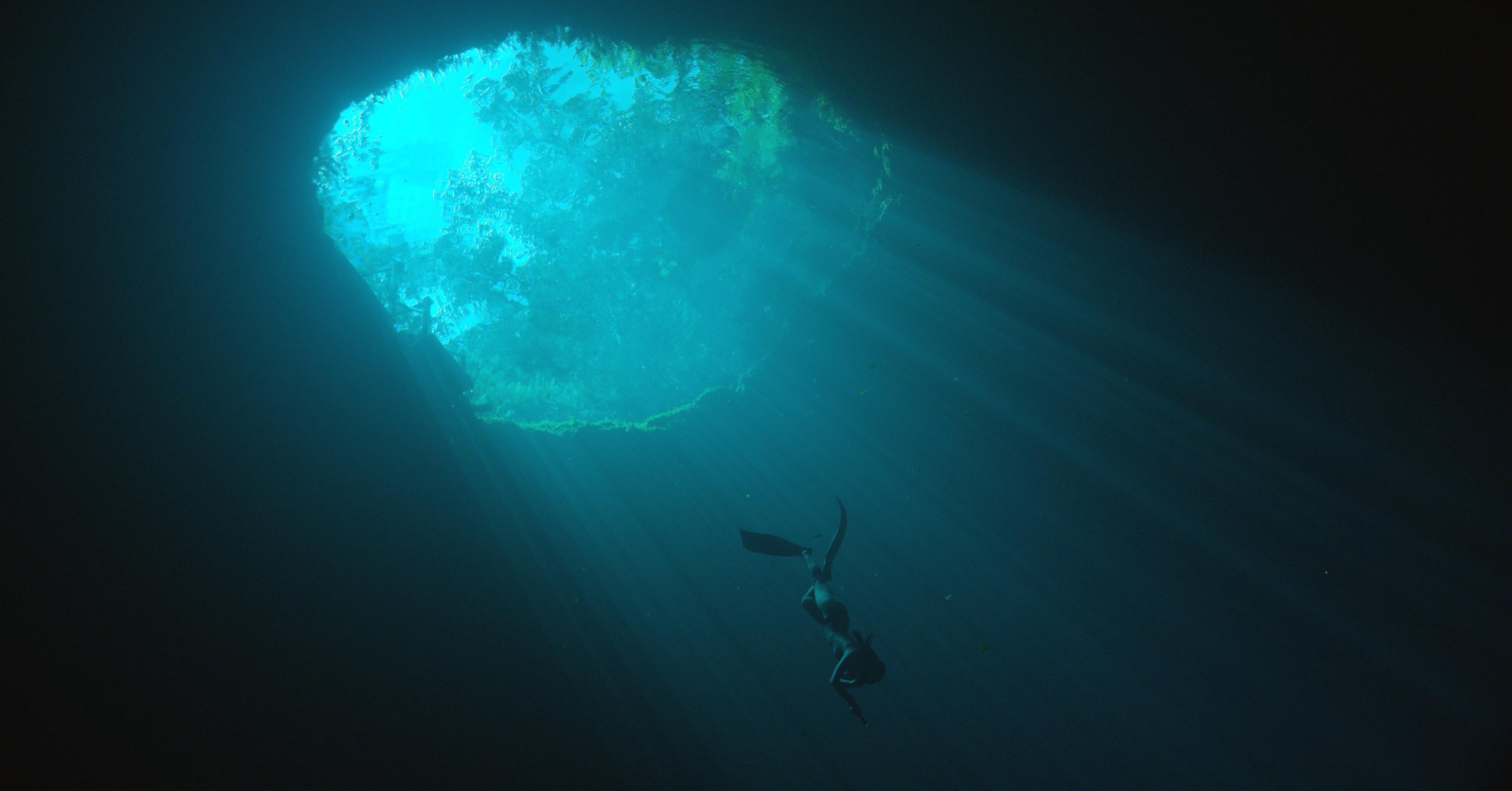 Woman scuba diving in underwater cave