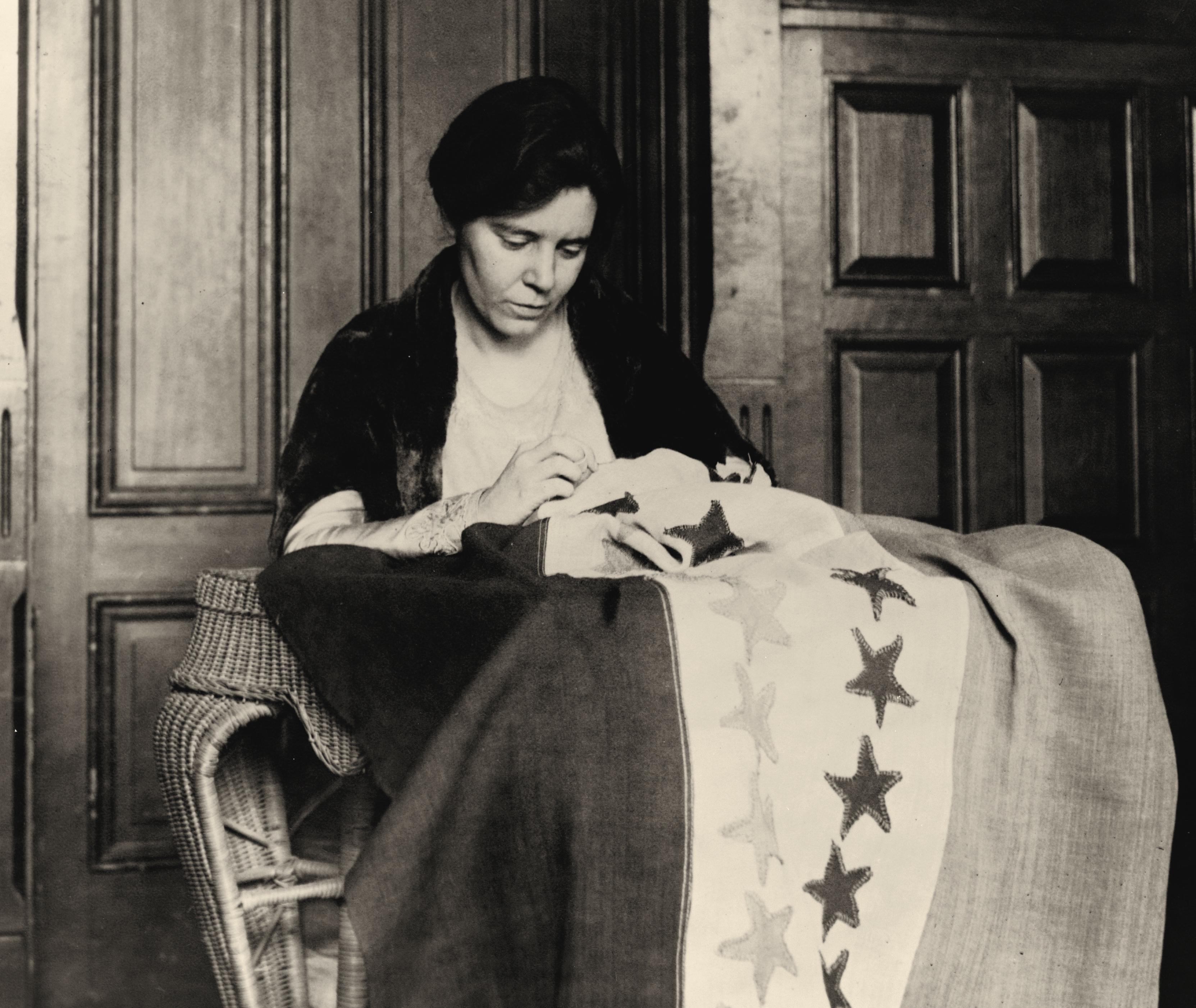 Alice Paul sews stars on flag marking state ratifications. Washington, D.C., 1920.