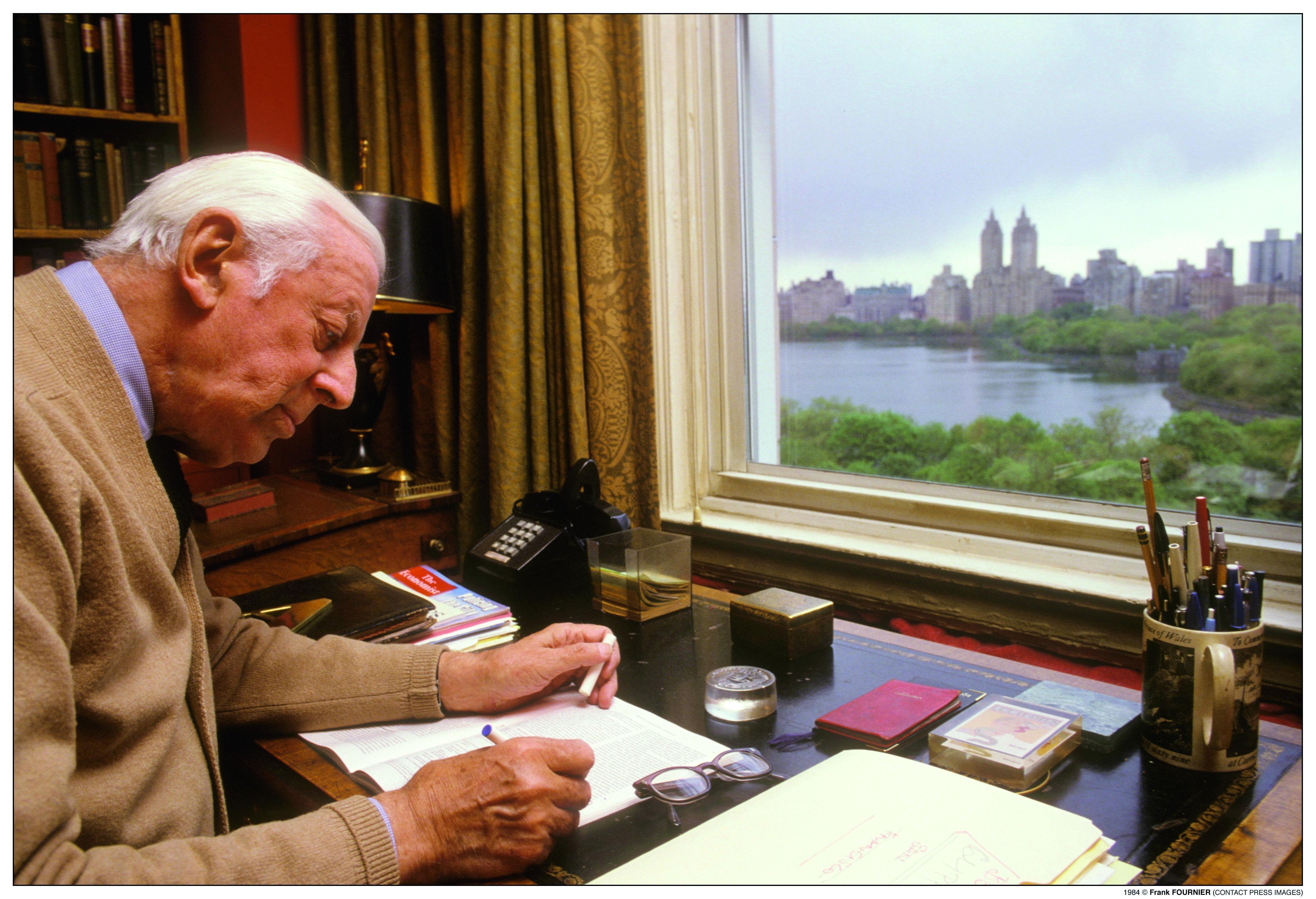Alistair Cooke at his desk.