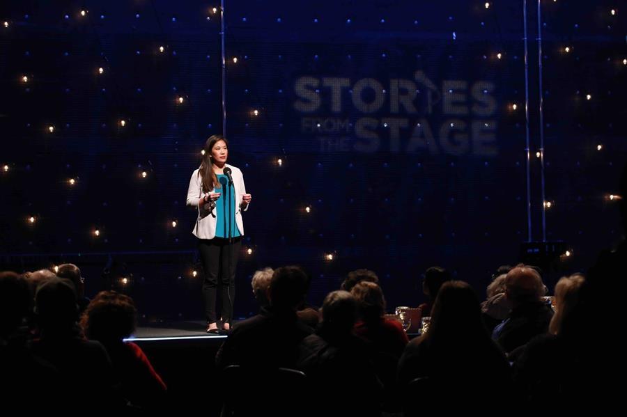 A woman speaking from the stage.
