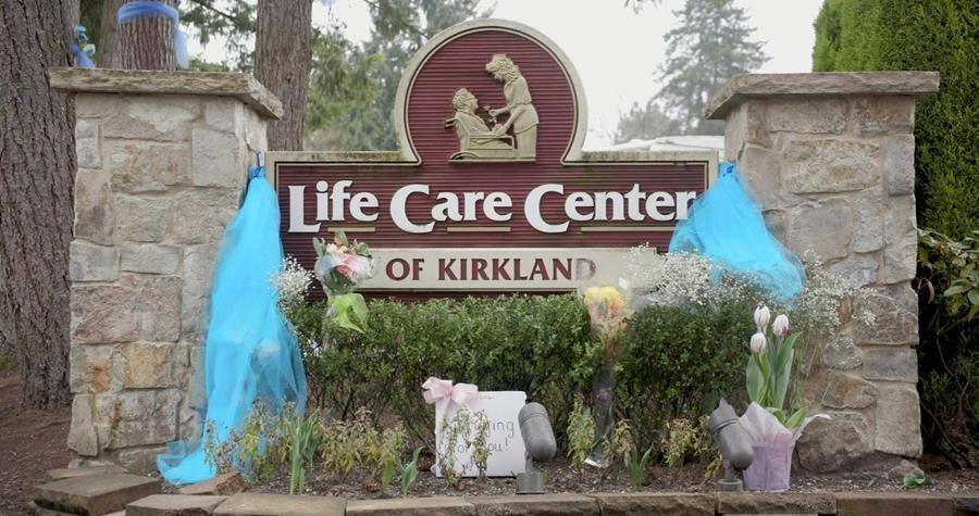 Photo of a nursing home sign with a memorial in front of it. 