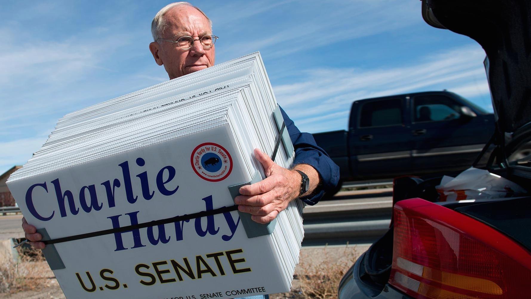 Charlie Hardy for U.S. Senate, holding a stack of yard signs.