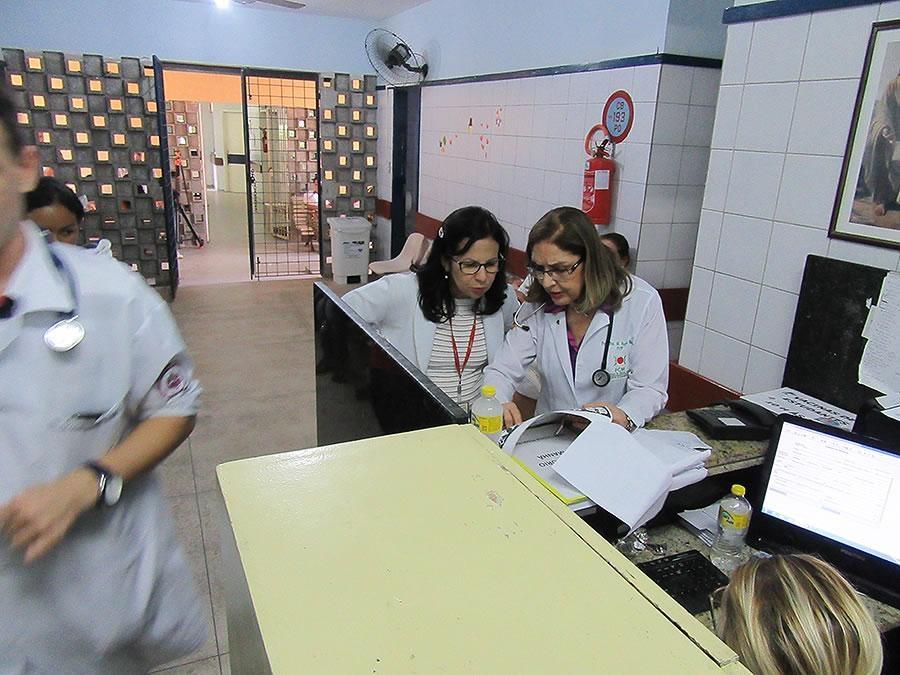 2 women in lab coats look at a document
