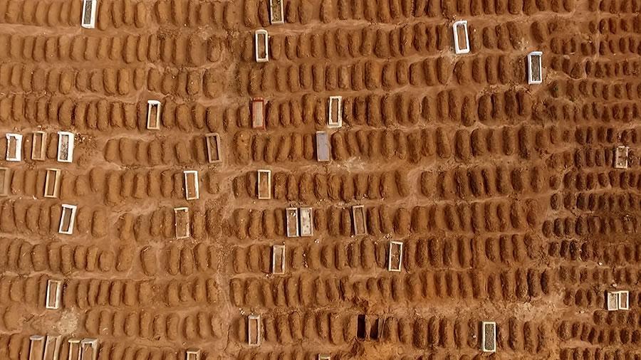 an aerial view of many rectangular red dirt mounds lined up in rows