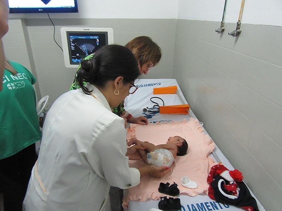 a woman in a doctor's coat examines a small baby on a table