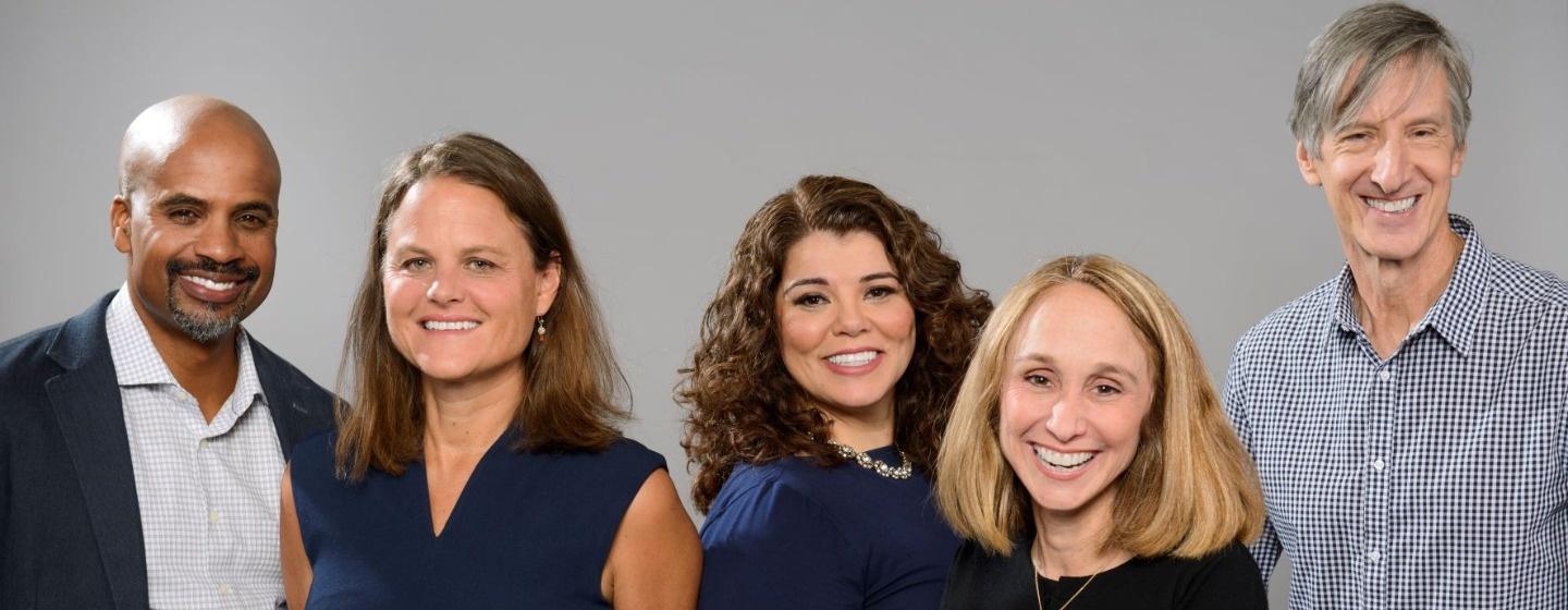 The hosts and executive producers of Retro Report stand in front of a gray background