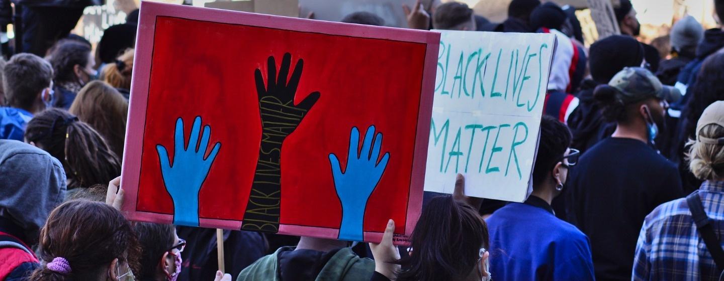 Black Lives Matter signs hoisted in a crowd