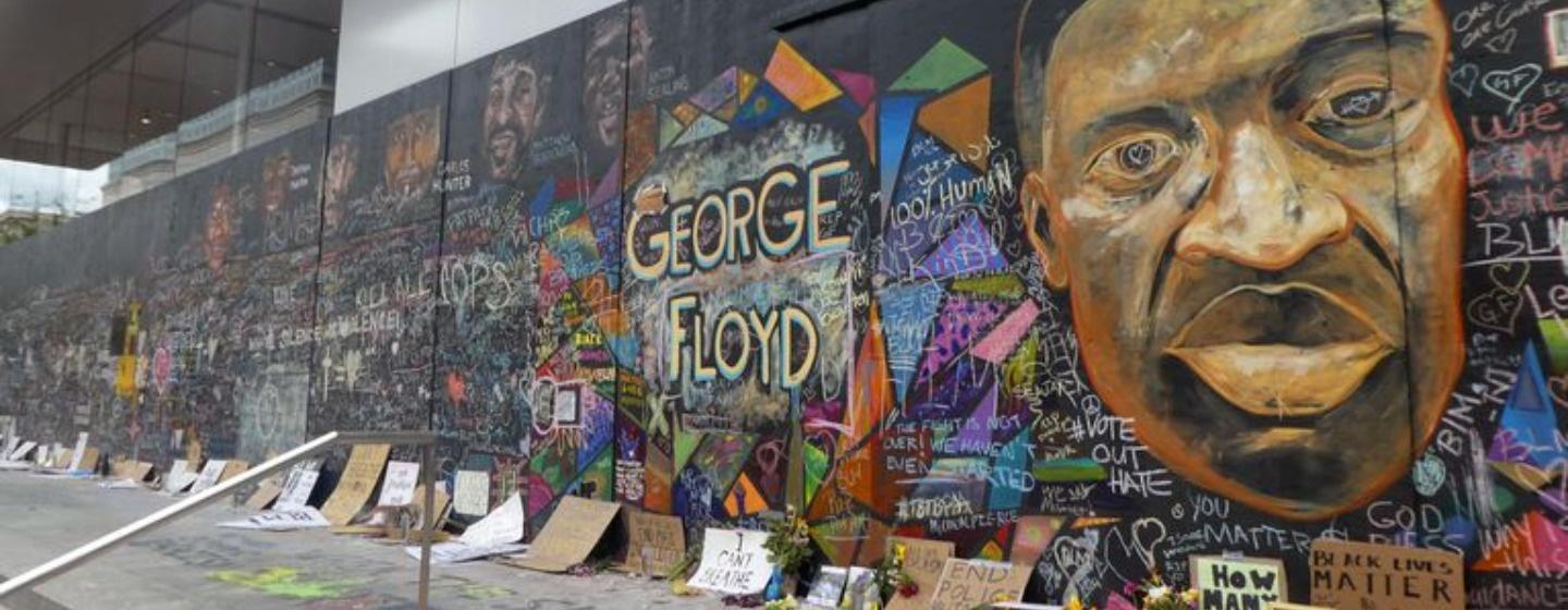 Mural of George Floyd on boarded-up storefront