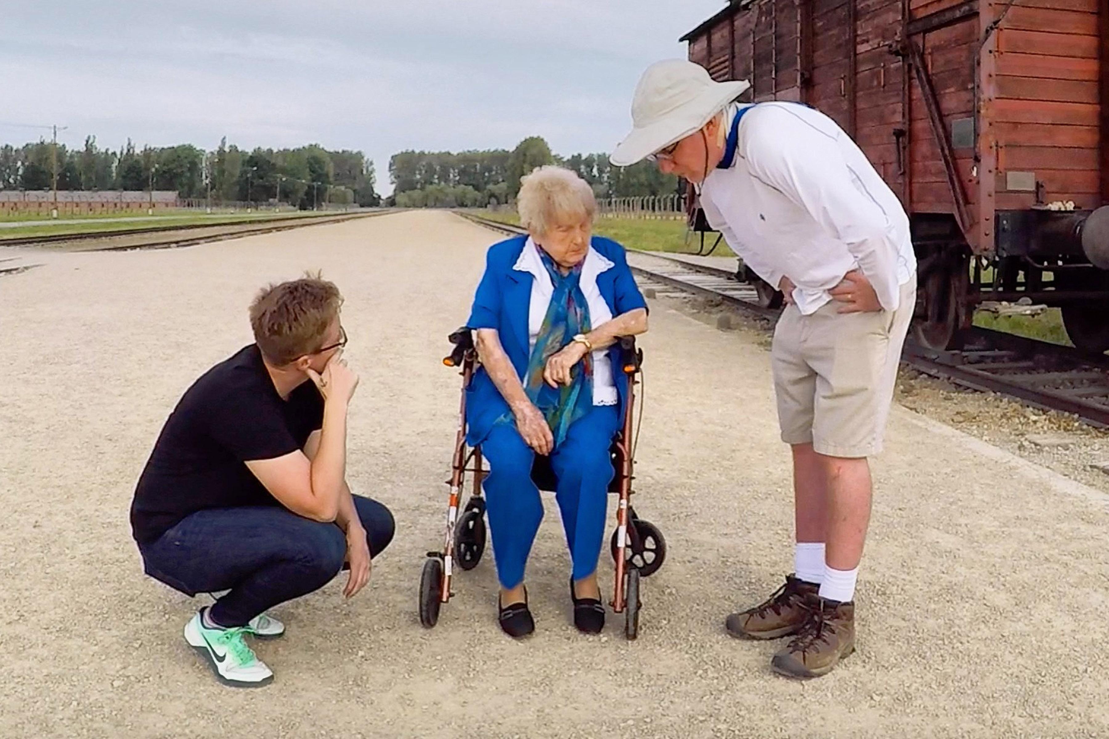 Mika Brown, Eva Kor and Ted Green standing in front of a cattle car at Auschwitz.