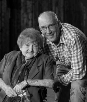 Eva Kor gives the peace sign at Auschwitz.