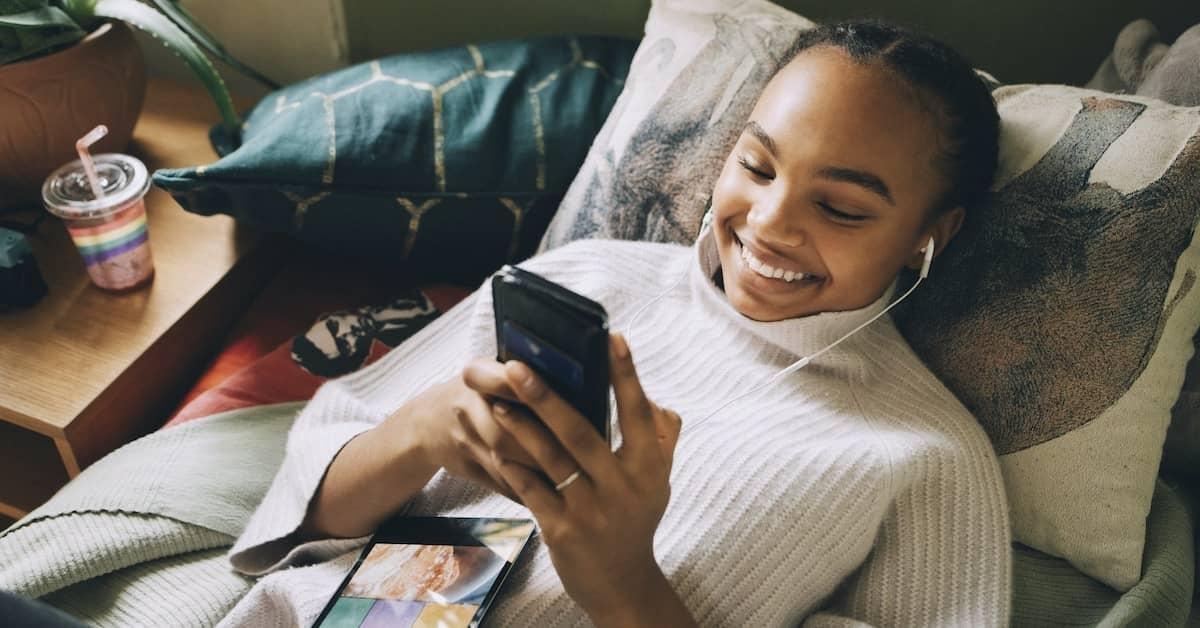 A woman listens to podcasts on her phone through earbuds