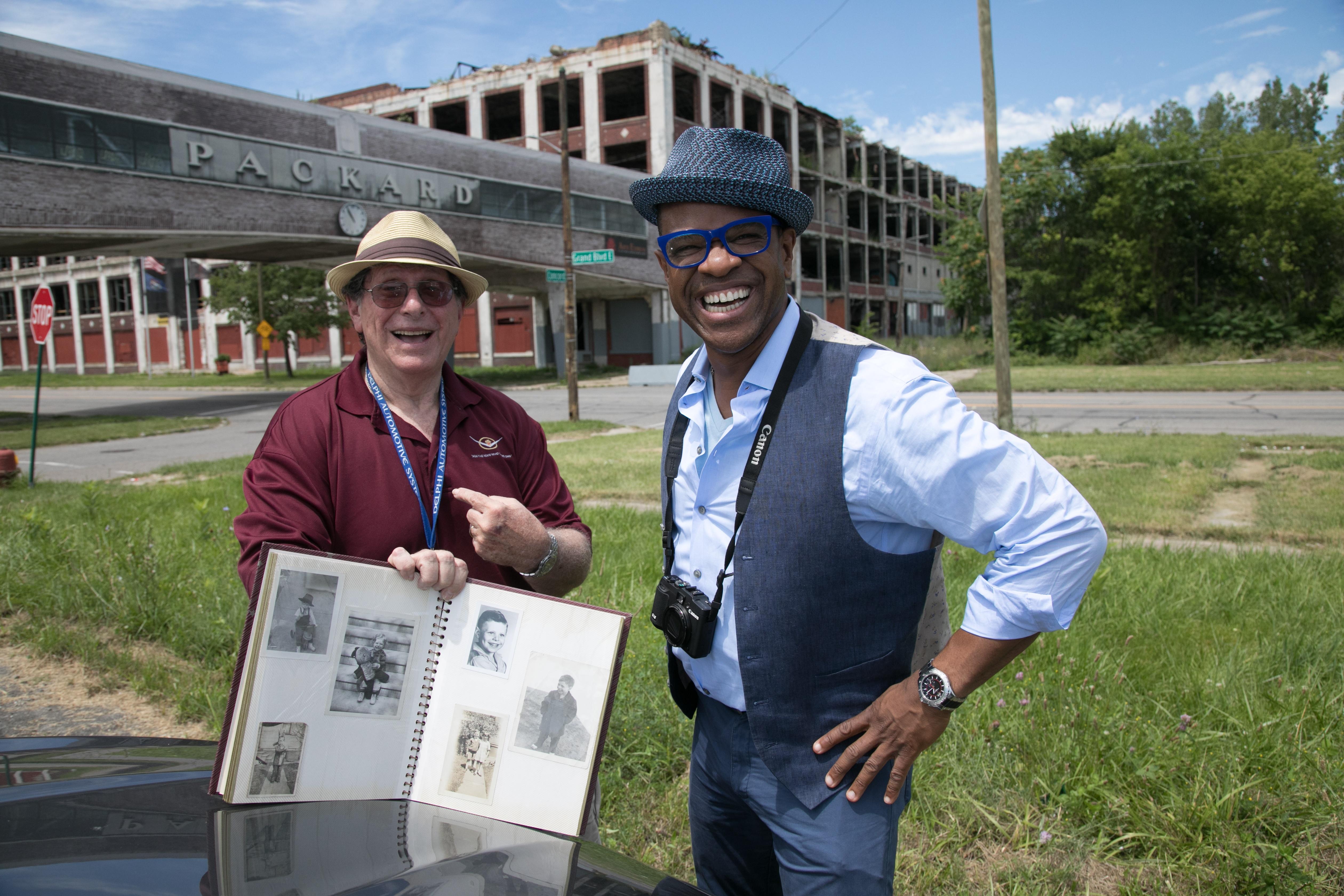 A man outside the Packard car plant in Detroit shows his family photo album to Thomas Allen Harris